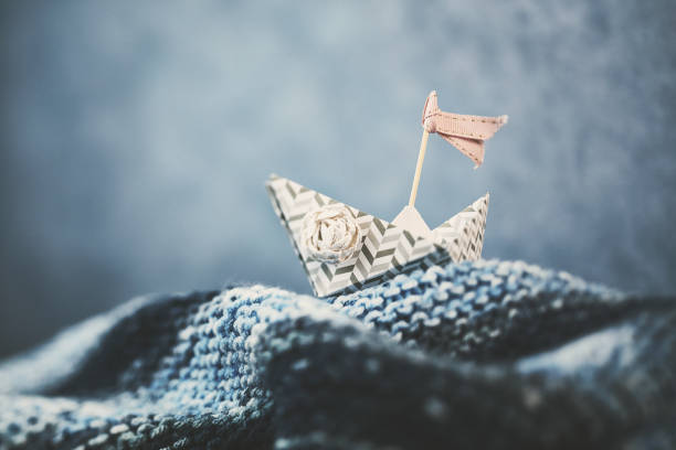 Handmade origami boat on handmade waves