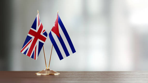 istock Cuban And British Flag Pair On A Desk Over Defocused Background 915975374