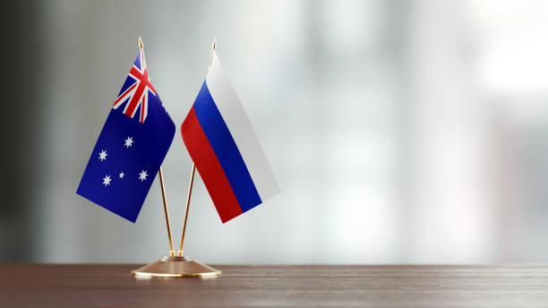 istock Australian And Russian Flag Pair On A Desk Over Defocused Background 915978422