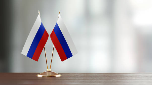 istock Russian Flag Pair On A Desk Over Defocused Background 915978844
