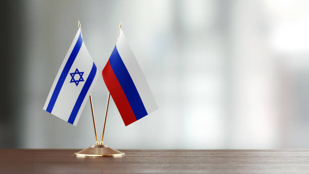 istock Israeli And Russian Flag Pair On A Desk Over Defocused Background 915978962