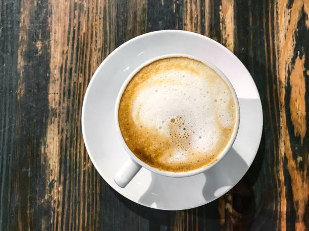 istock Cappuccino in white cup on old wooden table 915981712