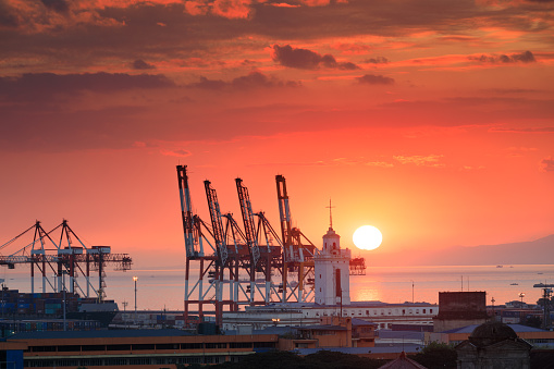 Beautiful sunset and industrial cargo cranes in Manila bay, Philippines