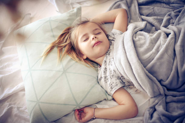 Morning in bed. Little girl sleeping in bed. Space for copy. one girl only stock pictures, royalty-free photos & images