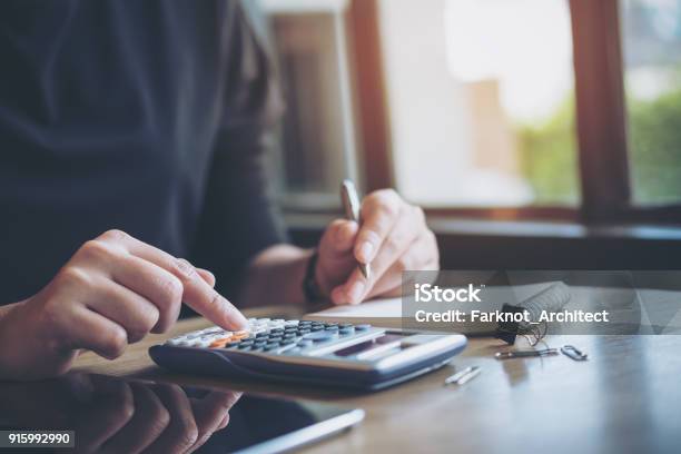 Una Mujer De Negocios Trabajando Usando Calculadora Y Escribir En El Cuaderno Foto de stock y más banco de imágenes de Calculadora