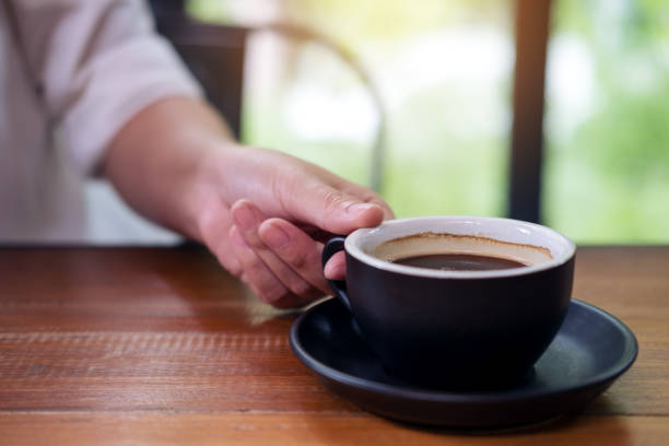 istock A hand holding a black cup of hot coffee 915993128