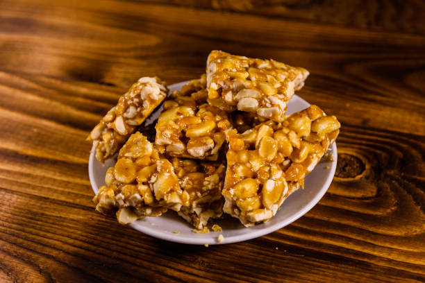 istock Ceramic plate with peanut brittles on wooden table. 915995456
