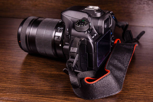 istock Modern dslr camera on the dark wooden table 915995810