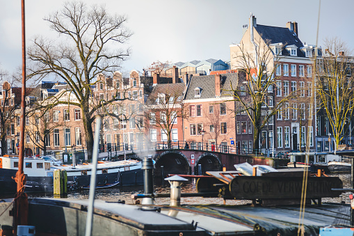 Amsterdam, Netherlands - December 16, 2017: View on the beautiful old buildings and water channel in Amsterdam city