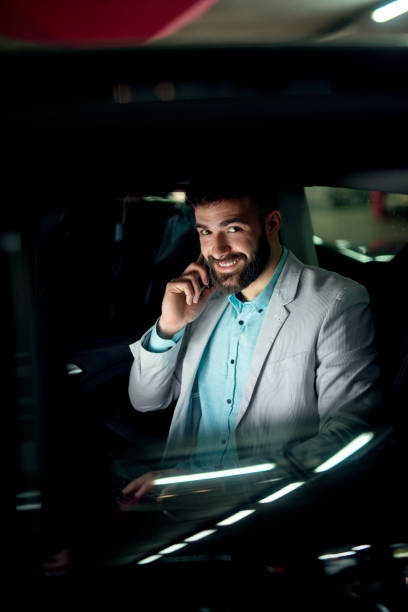 istock Businessman working talking sitting in a car at garage. 915996524