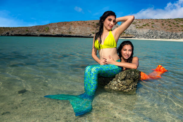 istock Two mermaid in love on the beach 916004548