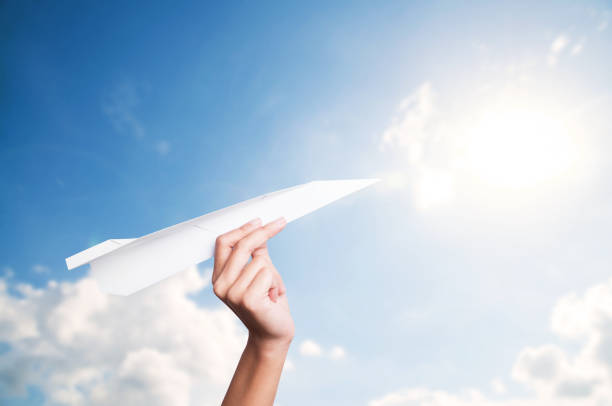 istock Hand holding paper plane toward cloudy blue sky concept new innovation and new creativity. 916008018