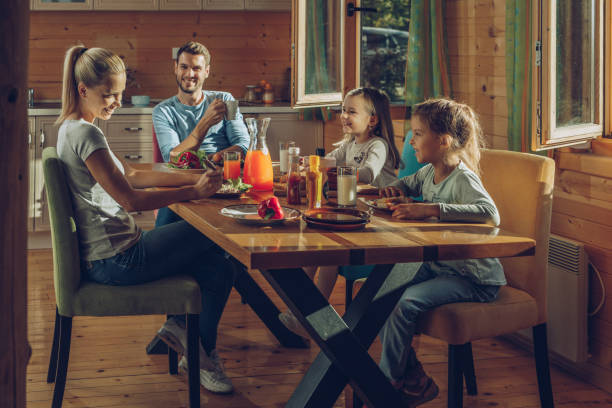 istock Happy parents talking to their small daughters while having a meal at home. 916008228