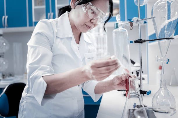 istock Concentrated mature lady conducting chemical experiment 916008322