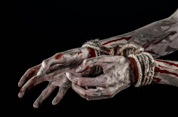 istock Hands bound,bloody hands, mud, rope, on a black background, isolated, kidnapping, zombie, demon 916011212