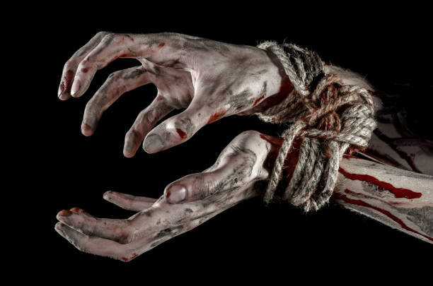 istock Hands bound,bloody hands, mud, rope, on a black background, isolated, kidnapping, zombie, demon 916011436