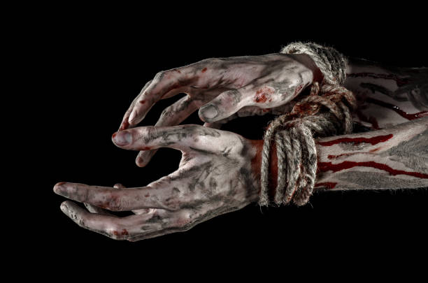 istock Hands bound,bloody hands, mud, rope, on a black background, isolated, kidnapping, zombie, demon 916011856
