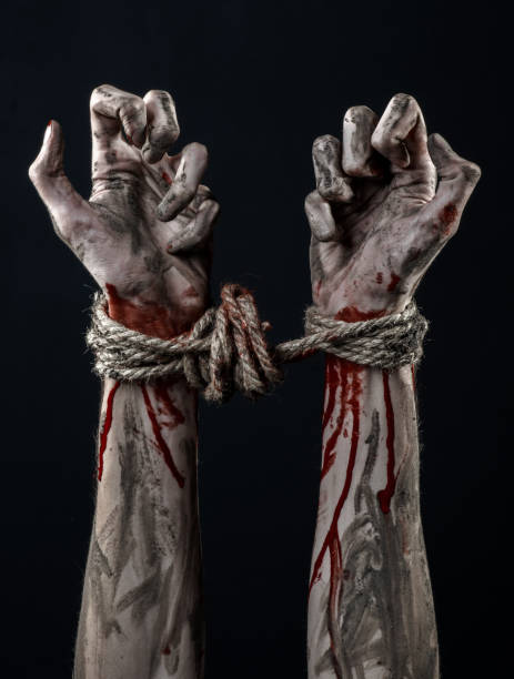 istock Hands bound,bloody hands, mud, rope, on a black background, isolated, kidnapping, zombie, demon 916012062