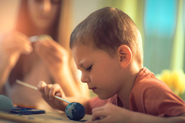 istock Brother and sister painted Easter eggs at the table 916012616