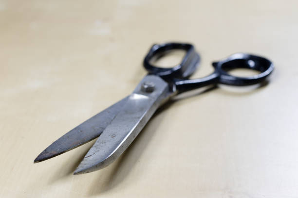 istock Garment accessories spread on a light wooden table. Threads, scissors and sewing needles in a tailoring workshop. Sewing station. 916012670