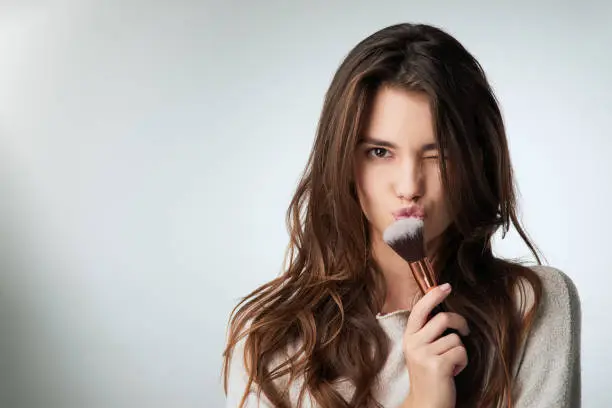 Studio shot of a beautiful young woman posing against a gray background