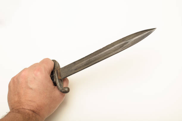 istock Hand holding old bayonet in close up view 916016222