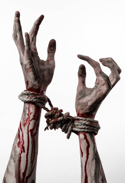 istock Hands bound,bloody hands, mud, rope, on a white background, isolated, kidnapping, zombie, demon 916017688