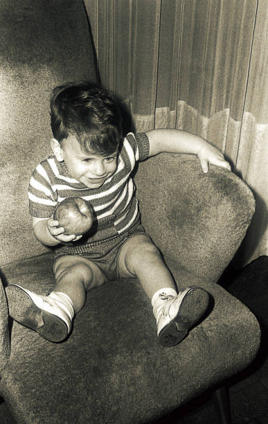 vintage kid sitting in a big armchair - 20th century style flash imagens e fotografias de stock