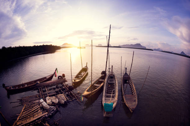 Wooden fishing boats with sunset scenery in the sea stock photo