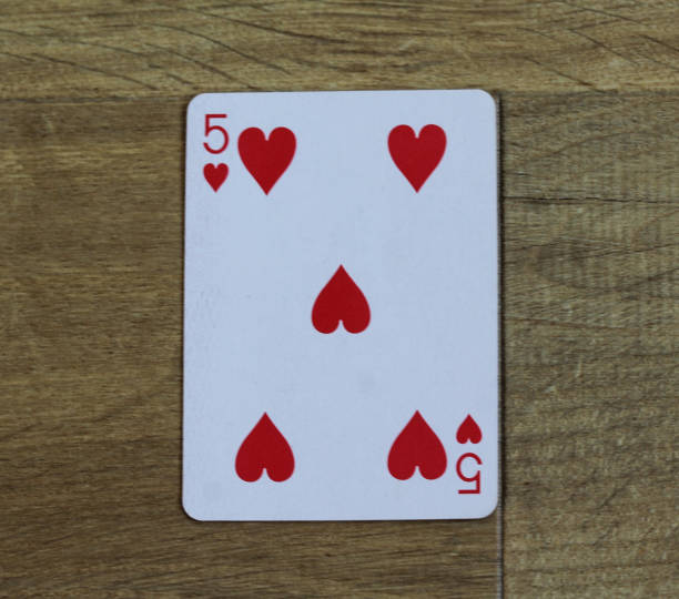 istock Poker card heart five on wooden background 916027562