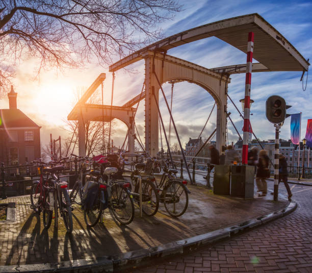 Amsterdam, Netherlands - December 16, 2017: People are cycling on the Magere Brug Skinny Bridge is over the river Amstel in the city centre of Amsterdam, Netherlands.  