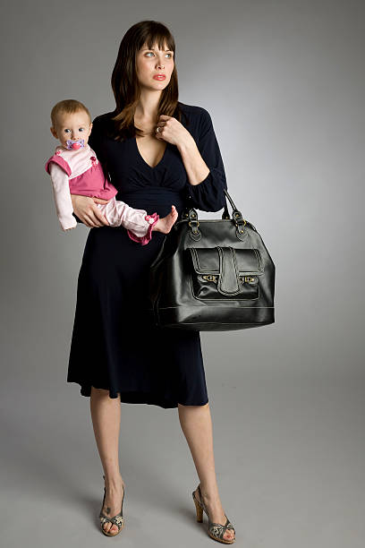 A working mom dressed in business attire holding her baby