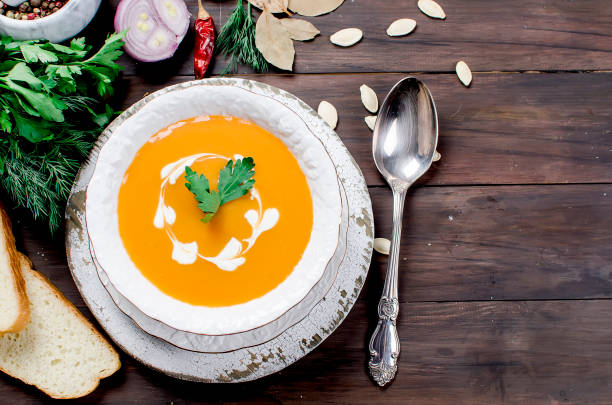 istock Pumpkin cream soup with pumpkin seeds  in white plate 916036472