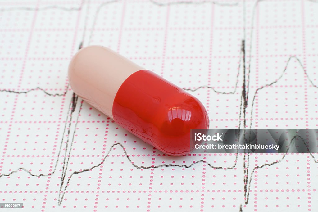 Pillola rossa su un Cardiogram cuore traccia - Foto stock royalty-free di Accudire