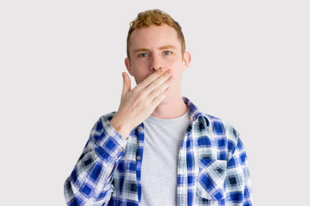 istock Serious Young Caucasian Man Covering Mouth with Hand 916040062