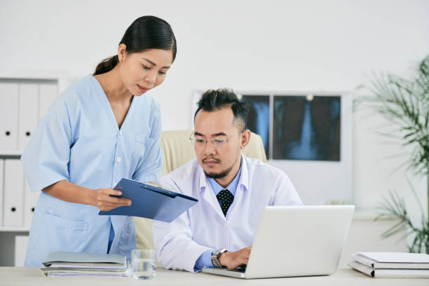 istock Nurse giving document to doctor 916040698