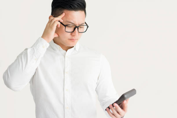 istock Confused Asian businessman using calculator 916047746