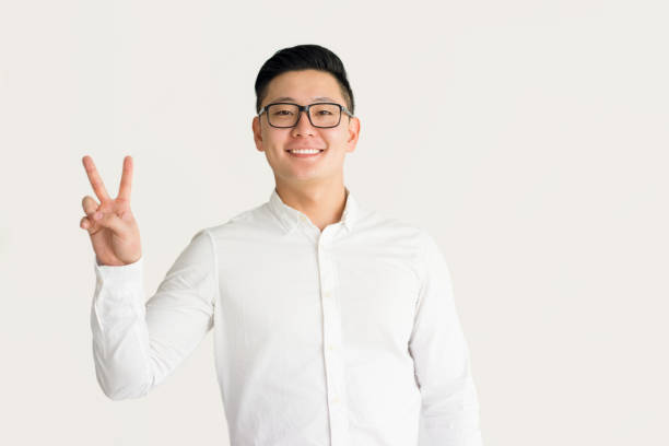 istock Ecstatic Korean male student showing peace sign 916047768