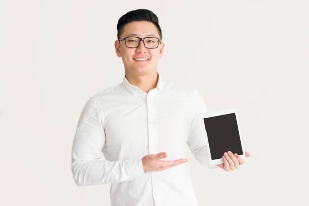 istock Satisfied Korean salesman presenting new device 916047794