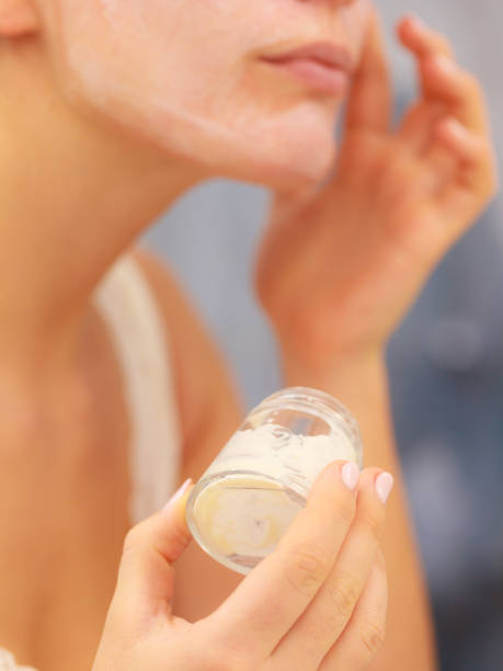 istock Woman applying mask cream on face in bathroom 916047994