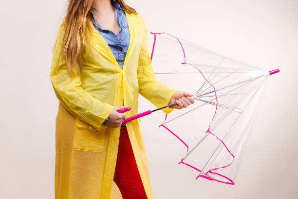istock Woman wearing waterproof coat opening umbrella 916048014