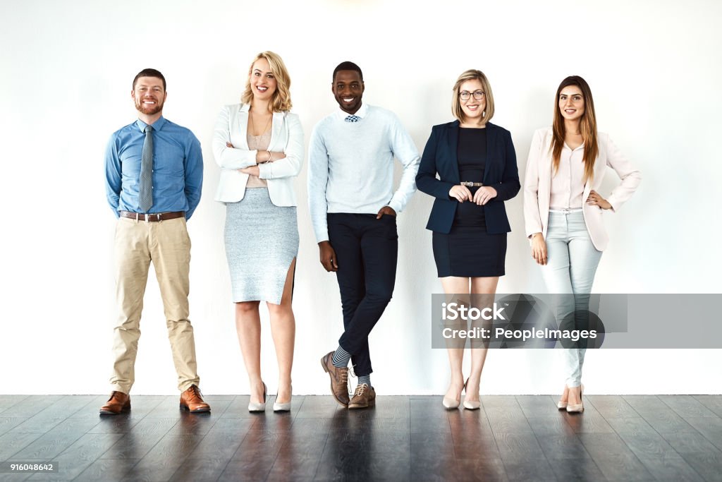 We call the shots Portrait of a group of confident work colleagues standing with their arms folded against a white background White Background Stock Photo
