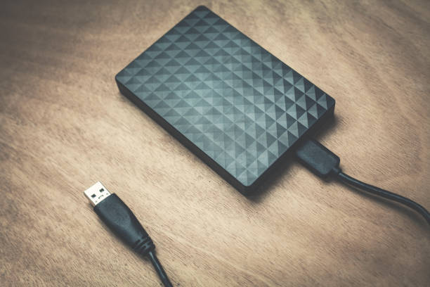 istock External hard drive on a wood background. 916048790