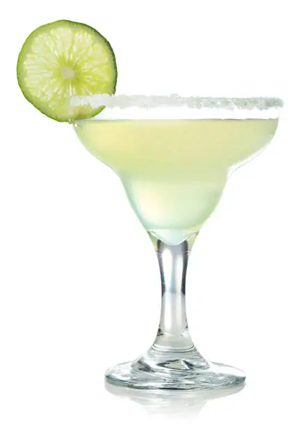 Glass of classic margarita cocktail decorated with slice of lime isolated on white background