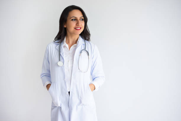 istock Smiling Pretty Female Doctor with Hands in Pockets 916058308