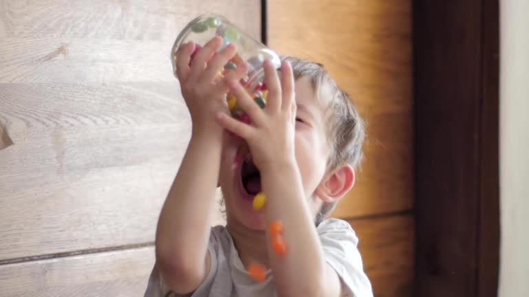 boy eating candies falling from jar