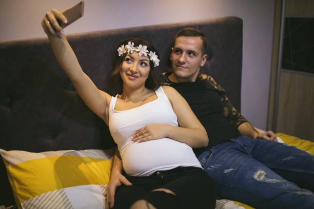 istock Pregnant couple at home taking selfie 916064062
