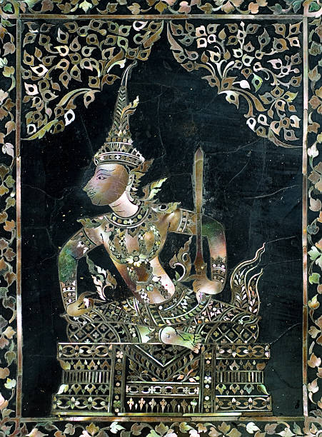 A plaque with Thai script surrounded by Intricate gold and coloured decorations on the exterior of a temple at Wat Arun, or the Temple of Dawn, in Bangkok, Thailand.