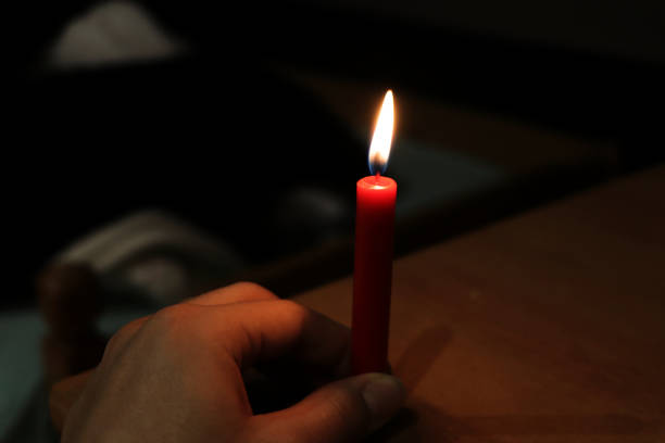istock The red candle with beautiful flame in hand 916064794