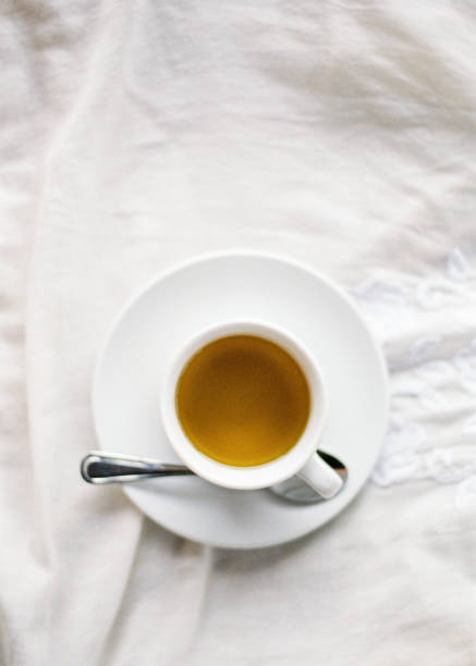 Flatlay of a cup of tea in bed stock photo
